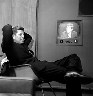 Sen. John F. Kennedy, Democratic presidential nominee, sits April 3, 1960, next to a playback of his televised appearance in Milwaukee for the Wisconsin presidential primary two days later. [ASSOCIATED PRESS FILE]