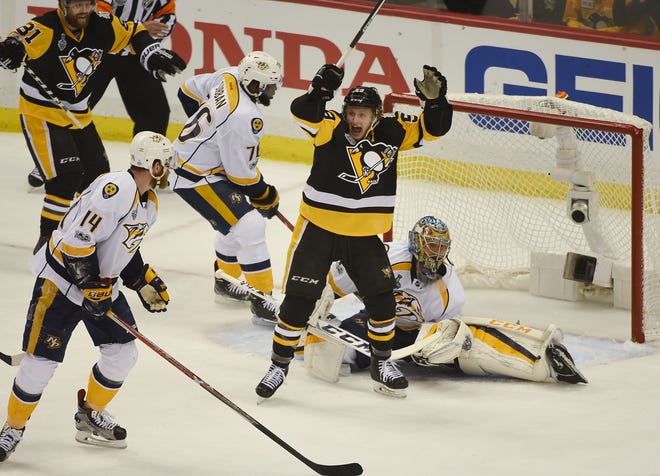 Jake Guentzel (59) celebrates after a goal by Evgeni Malkin (71) during the first period of the Pittsburgh Penguins game against the Nashville Predators in Game 1 of the Stanley Cup Final on Monday at PPG Paints Arena in Pittsburgh.