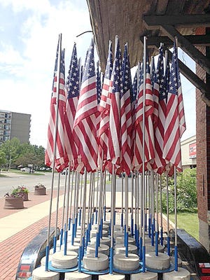 American flags sit on a trailer early this week, before they were placed in front of downtown businesses. [COURTESY PHOTOS]