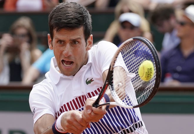 Novak Djokovic returns the ball to Marcel Granollers during their first round match Monday at the French Open. Djokovic won in straight sets. [CHRISTOPHE ENA/THE ASSOCIATED PRESS]