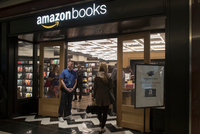 In this Thursday, May 25, 2017, photo, a woman is greeted by an Amazon Books store employee as she arrives at the store in the Time Warner Center at Columbus Circle, in New York. Amazon opened the retail store Thursday. Amazon, the e-commerce giant that changed how people shop for books, toilet paper and TVs, hit a new milestone Tuesday, May 30: Its stock topped $1,000 for the first time. (AP Photo/Mary Altaffer)