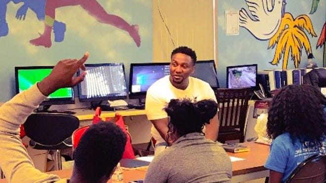 Sean Terrell, director of E-Roadmap, a non-profit that helps empower kids by developing their social and entrepreneurial skills, works with a group of Lake Worth kids to hone their business ideas. (Contributed)