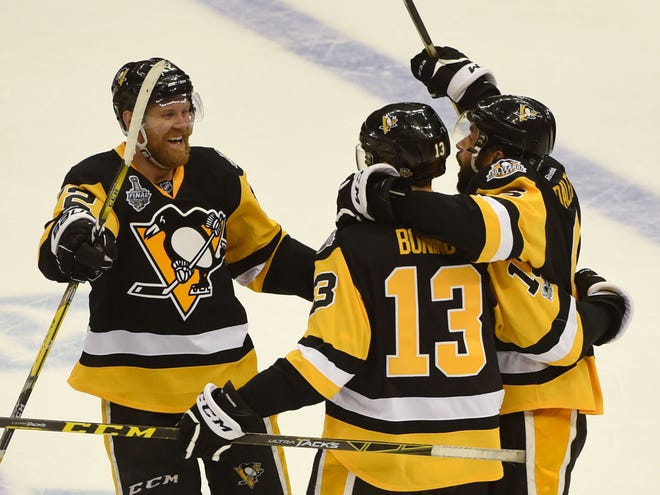 Patric Hornqvist (72) and Trevor Daley (6) celebrate with Nick Bonino (13) after Bonino's empty-net goal sealed the Penguins' 5-3 win over the Predators in Game 1 of the Stanley Cup Final at PPG Paints Arena in Pittsburgh.