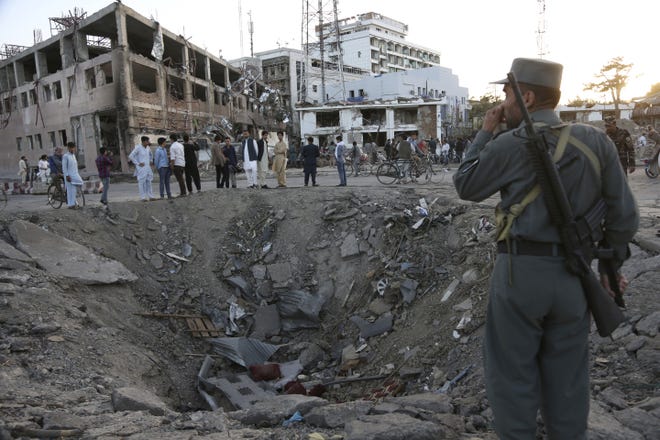 Security forces stand next to a crater created by massive explosion in front of the German Embassy in Kabul, Afghanistan, Wednesday, May 31, 2017. The suicide truck bomb hit a highly secure diplomatic area of Kabul killing scores of people and wounding hundreds more. THE ASSOCIATED PRESS