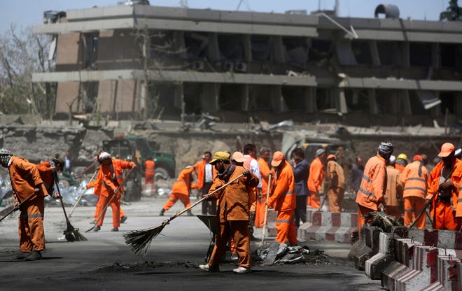 Afghan Municipality workers sweep a road in front of the German Embassy after a suicide attack in Kabul, Afghanistan, Wednesday, May 31, 2017.