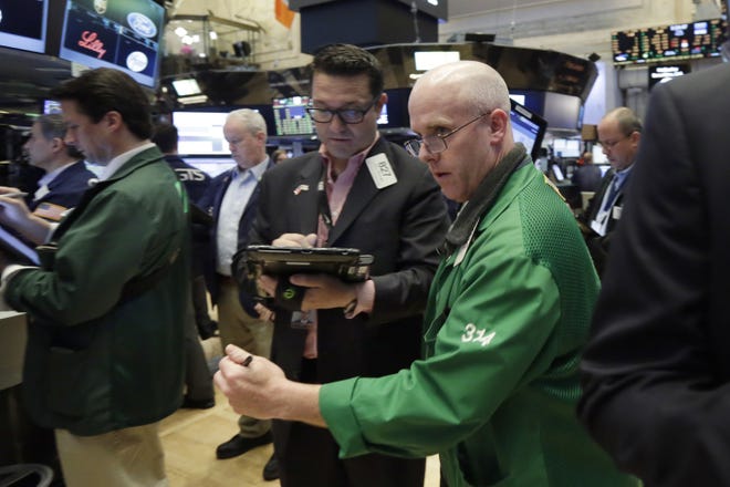 In a Friday, May 26, 2017 file photo, Kevin Walsh, right, moves between fellow traders as he works on the floor of the New York Stock Exchange. THE ASSOCIATED PRESS