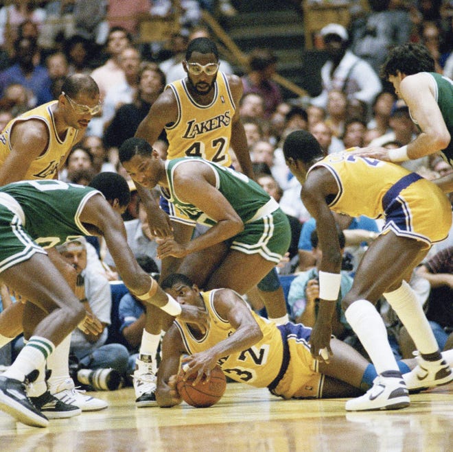 Los Angeles Lakers' Earvin "Magic" Johnson scrambles for the ball on the floor of The Forum during the NBA finals in Inglewood, Calif. [AP FILE]