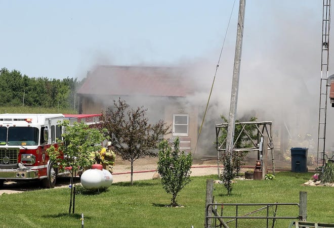 Allen Township fire personnel work to bring the fire undercontrol Thursday afternoon. ANDY BARRAND PHOTO