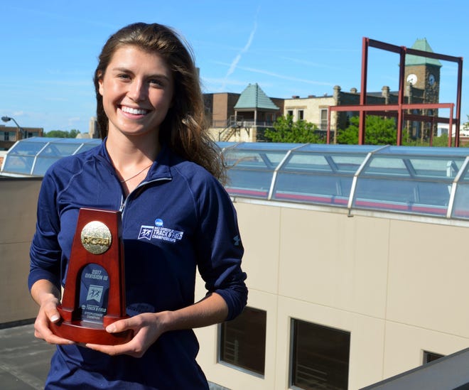 Hope's Erin Herrmann stands atop downtown Holland after winning the national championship in the steeplechase. [Dan D'Addona/Sentinel staff]