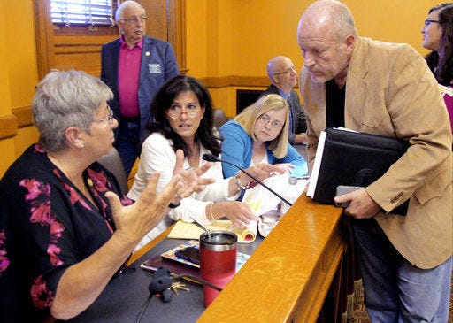State Rep. Brenda Landwehr (left), R-Wichita, confers with lead House negotiator Larry Campbell (right), R-Olathe, during talks on school-funding legislation Friday at the Statehouse in Topeka. Also engaged in the conversation are Rep. Melissa Rooker (second from left), R-Fairway, and Melinda Gaul (center, right), an aide to House Speaker Ron Ryckman Jr., R-Olathe.