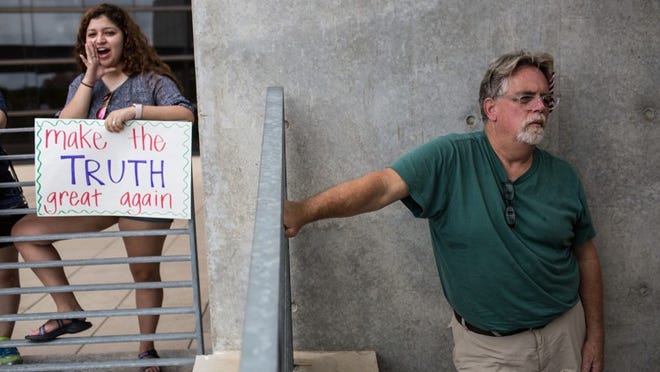 Emily Guardiola and David Thornberry listen to speakers at a ‘March for Truth’ rally Saturday where demonstrators gathered to demand an independent investigation into the Trump administration’s possible ties to Russia. (TAMIR KALIFA/ AMERICAN-STATESMAN)