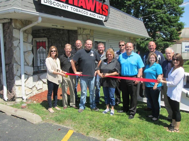 Members of the Canton Area Chamber of Commerce join with the staff of JB Hawks Discount Tobacco for a ribbon cutting Friday during the store's grand opening.