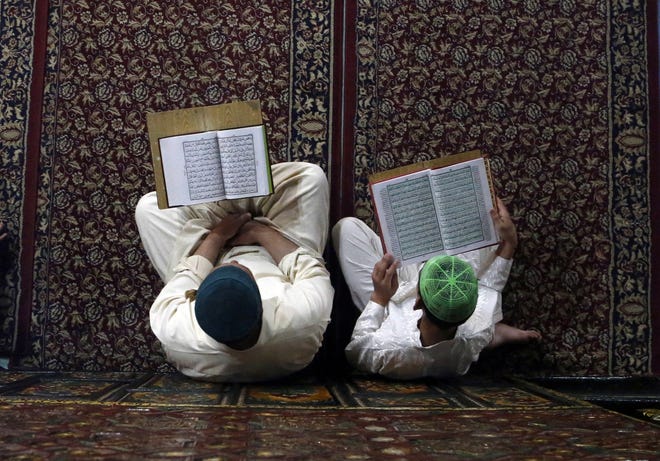Kashmiri Muslims read verses from the Quran, Islam's holy book, inside the shrine of Shah-e-Hamdan during the holy month of Ramadan in Srinagar, Indian-controlled Kashmi. Muslims across the world are observing the holy fasting month of Ramadan, where they refrain from eating, drinking and smoking from dawn to dusk and also are encouraged to increase their prayer, reading of the Quran and acts of charity. [MUKHTAR KHAN/ASSOCIATED PRESS]