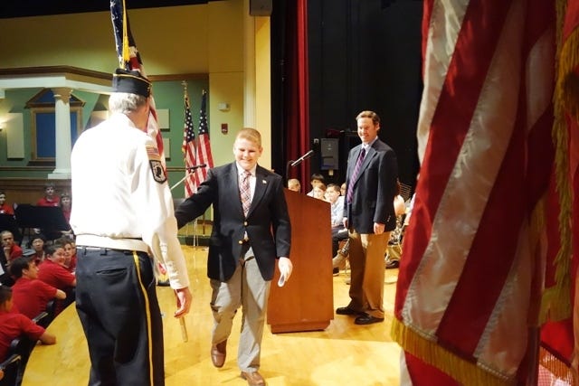 Ryan Heffler moves his standard from one end of the stage to the other during the 93rd annual Transfer of Flags on May 24 at Wilson Middle School.



[Wicked Local Photo by Maureen Sullivan]
