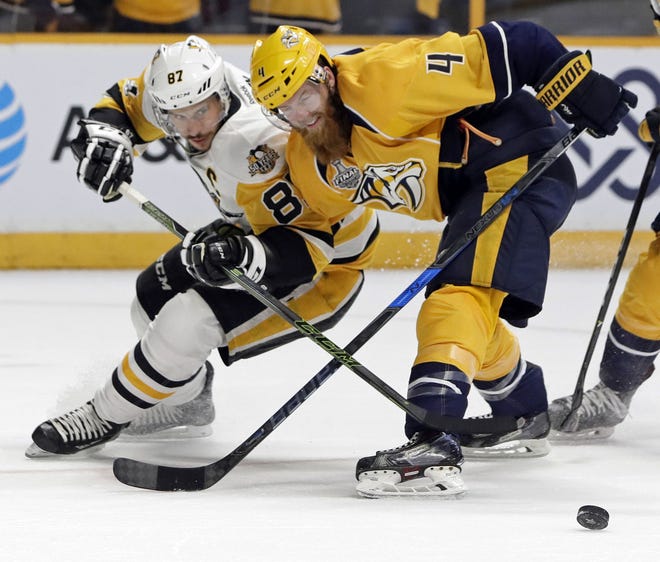 Nashville Predators defenseman Ryan Ellis (4) and Penguins center Sidney Crosby (87) battle for the puck during the second period in Game 3 of the Stanley Cup Final on Saturday in Nashville, Tenn.