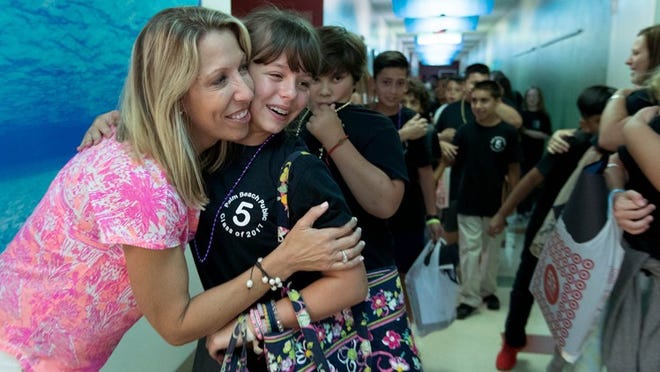 Palm Beach Public School principal Christie Schwab hugs fifth-grader Sophia Paret on the last day of school. Sophia will attend middle school at St. Ann next year. (Allen Eyestone / Daily News)