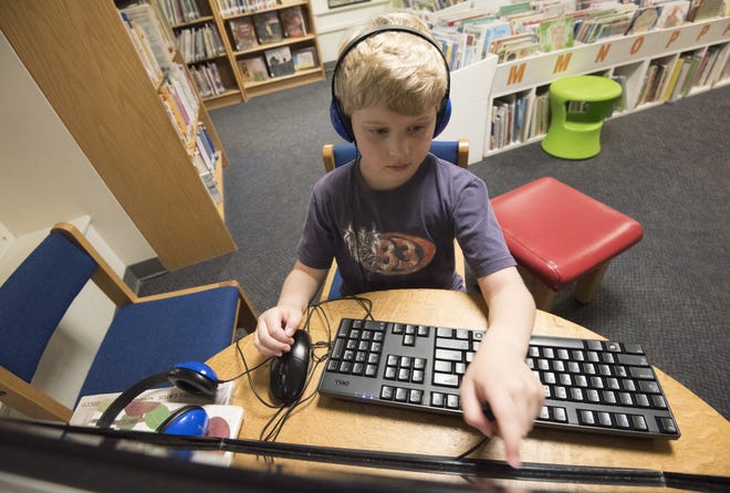 Robert Gagnon, 7, uses an interactive learning program at the Dover Public Library. Technology is nearly as standard in libraries today as books. [John Huff/Fosters.com]