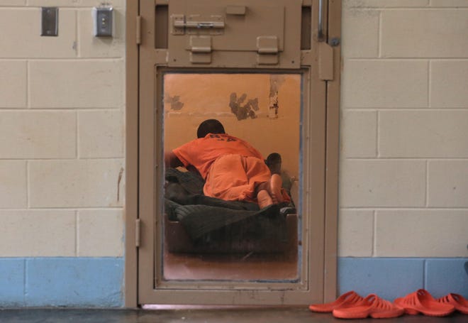 A man rests on a mat with a blanket on the floor May 18 at the Bay County Jail. [PATTI BLAKE/THE NEWS HERALD]