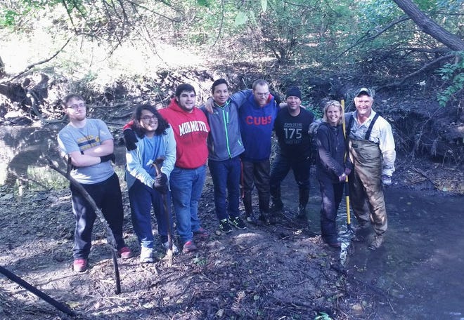 Phi Delta Theta fraternity as well as members of the college community lend a hand in cleaning up a local creek as part of an Eagle project.
