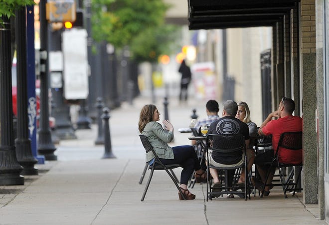 Restaurant owners hope city officials continue to make downtown Erie friendly to businesses like theirs, which is why any talk of charging a fee for sidewalk easements concerns them. Outdoor dining is a key way many enjoy the city's summer evenings. Friends, from left, Cara Horchen, Josh Gadley, both 29, Jaimie Parmenter, 27, and Shane Spaniol, 28, eat outside at Voodoo Brewery in Erie. [GREG WOHLFORD/ERIE TIMES-NEWS]
