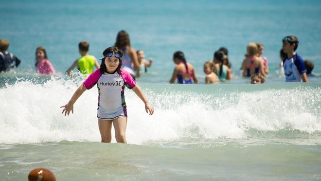 Rosavita Gilken, 7, cools off in the ocean with fellow Camp Palm Beach campers at Midtown Beach in March in Palm Beach. (Meghan McCarthy / Daily News File Photo)
