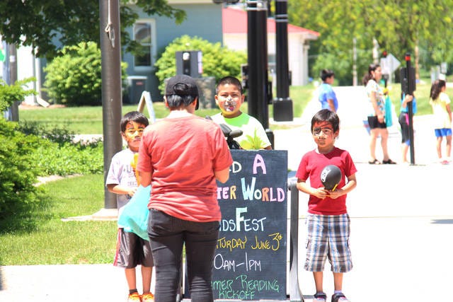 Kids pose in front of the Perry Public Library’s sign celebrating the “Build a Better World” summer reading program. PHOTO BY KILEY WELLENDORF/THE PERRY CHIEF