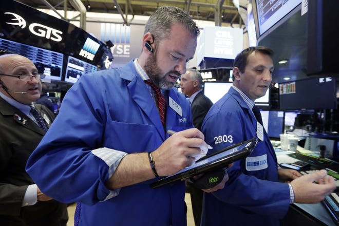 In a Tuesday, May 23, 2017 file photo, trader Kevin Lodewick, center, works on the floor of the New York Stock Exchange. U.S. stock indexes edged mostly lower in trading Monday, June 5, 2017. THE ASSOCIATED PRESS