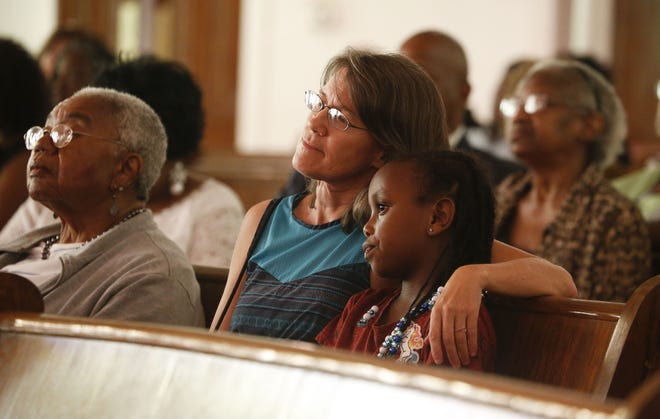 Eve Passerini hugs her daughter, Ali, as they listen to the story of what happened on Bloody Tuesday during a service to commemorate the event Sunday evening at First African Baptist Church in Tuscaloosa. [Staff Photo/Gary Cosby Jr.]