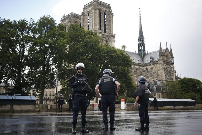 Police officers seal off the access to Notre Dame cathedral in Paris, France, Tuesday, June 6, 2017. Paris police say an unidentified assailant has attacked a police officer near the Notre Dame Cathedral, and the officer then shot and wounded the attacker. THE ASSOCIATED PRESS
