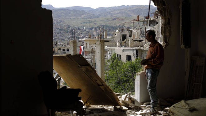 A man checks the damageMay 18 at the mountain resort town of Zabadani in the Damascus countryside of Syria. (Associated Press, file)
