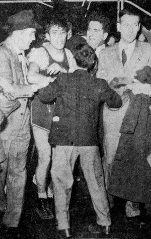 Jimmy Piersall battles through the crowd after leading Leavenworth High past Durfee in the 1947 New England basketball championship game at Boston Garden.