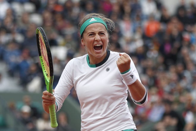 Jelena Ostapenko clenches her fist after scoring a point against Caroline Wozniacki during their quarterfinal match Tuesday at the French Open. [Petr David Josek/The Associated Press]