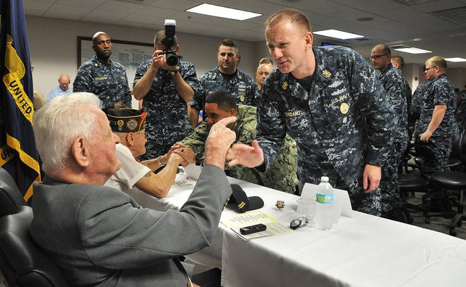 Army Air Corp veteran Andy Ramotnik (left) speaks with Steven Giordano, the master chief petty officer of the U.S. Navy, as he thanked each veteran after the event. (Bruce Lipsky/Florida Times-Union)