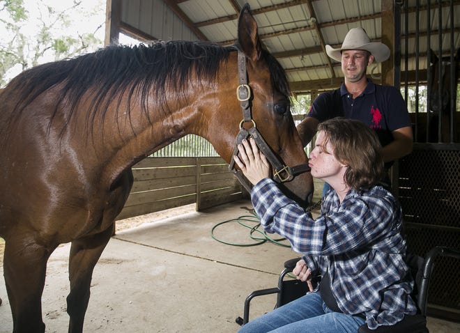 Joe Williams' sister Katie Williams gives her horse Toni a kiss on the nose after Joe retrieved him from his paddock Friday, June 2, 2017. Katie was badly injured, including a serious brain injury, in a traffic crash March 19, 2016. She now lives with Joe and his family at their farm in northwest Marion County. Since she has been back around horses, Katie has responded better than doctors said she would and they continue to help in her recovery. [Doug Engle Ocala-Star-Banner]2017