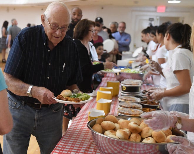 Welbur Delpa fills his plate during Wednesday's spaghetti dinner fundraiser at the Stockton Memorial Civic Auditorium, organized to benefit victims of the May 25 pallet fire. [CALIXTRO ROMIAS/THE RECORD]