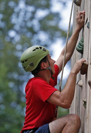 Andrew Rogers climbs a 35-foot wall during Boy Scout summer camp at Camp Horne in Cottondale on June, 17, 2015. Camp Horne covers almost 500 acres of land and about half is used by summer camps. [Staff file photo]