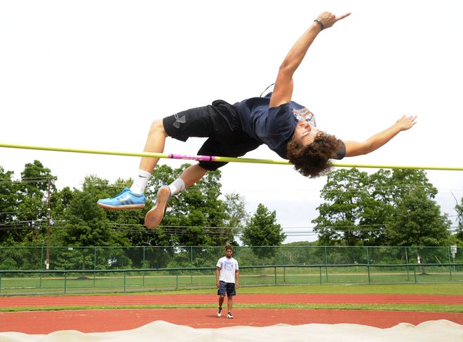 Hunter Daly jumps and Ladarius McNeil watches during practice Thursday at Florence High School for Saturday's Meet of Champions where they will be competing in the high jump. They finished first and second in the state Group 1 meet last Saturday.