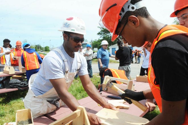 Derek DePina, of Brockton High School, right, makes a tool box with help from professional carpenter Andree Allen during Brockton Area Construction Career Day on Thursday, June 8, 2017 at the Brockton Fairgrounds.