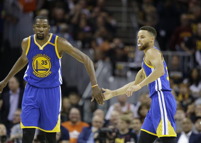 Warriors forward Kevin Durant, left, and Stephen Curry play against the Cavaliers Wednesday during the second half of Game 3 of the NBA Finals in Cleveland. Game 4 is tonight. [THE ASSOCIATED PRESS]