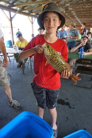 A young angler proudly shows his catch from an earlier Youth Fishing Derby.