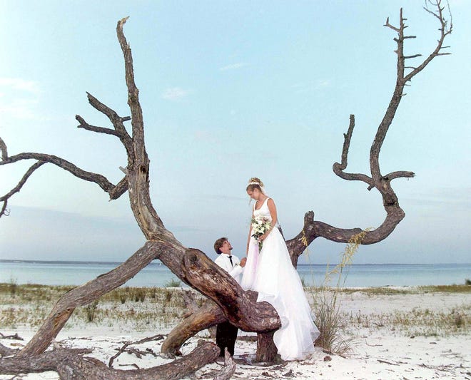 Derrick and Lindsey Puckett pose for sunset portraits on the beach in Gulfview Heights in Walton County after their wedding ceremony. [FILE PHOTO/DAILY NEWS]