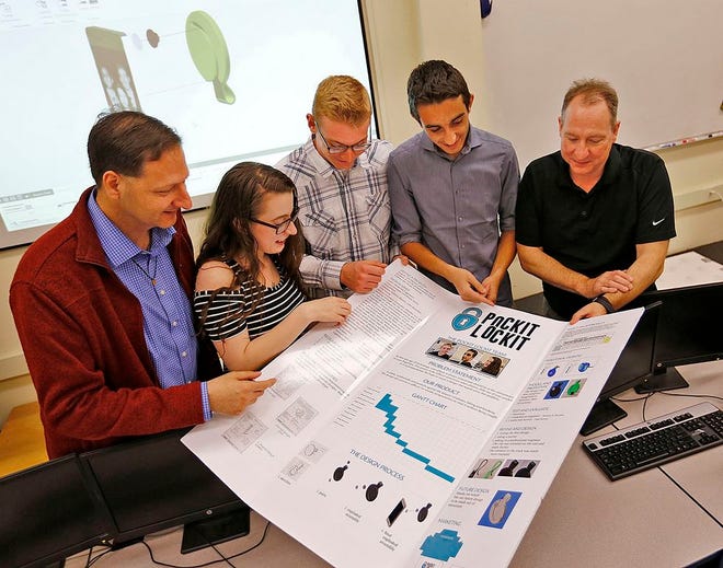 Engineering teacher Michael Meyes, Erin Young, Andrew Bryant, John Bourikas and engineering teacher Dan Hamill go over the poster made for the national SkillsUSA competition.