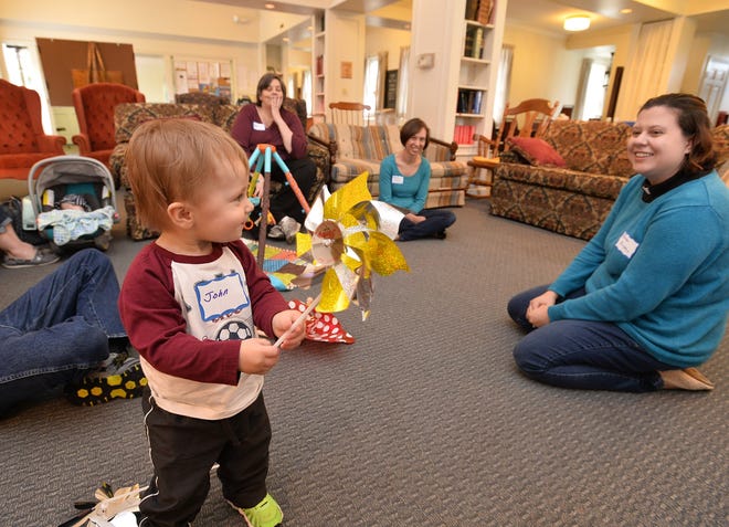 John Kitcho, 1, left, of Erie, plays with a pinwheel as the Rev. Kristen Papson, at right, engages him during a Wiggles 'n' Worship service Wednesday at Mount Calvary Lutheran Church in Erie. Papson developed the weekly event to better connect toddlers and their families with worship and faith on a level that is useful and fun for young children. [CHRISTOPHER MILLETTE/ERIE TIMES-NEWS]