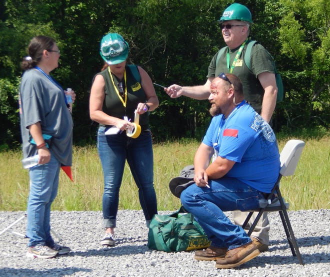 CERT volunteers label a victim with red tape, meaning critical injuries during the emergency excercise at the Etowah County Megasite Saturday. [Donna Thornton/Gadsden Times]