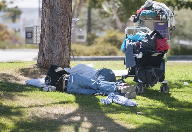 Two men sleep in the shade with their belongings packed in shopping and baby carts. Victorville is preparing a committee to look at solutions to homelessness particularly in the Old Town area. (James Quigg, Daily Press)