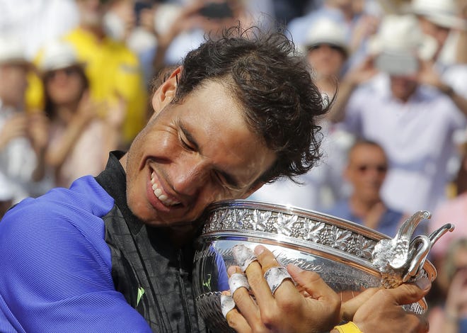 Rafael Nadal hugs the cup after defeating Stan Wawrinka in the finals of the French Open on Sunday in Paris. The title was Nadal's 10th at the French Open and 15th major championship overall. [Michel Euler/The Associated Press]