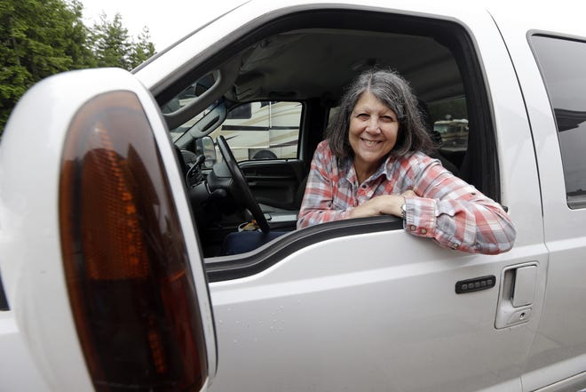 In this photo taken Thursday, Nancy Zingheim smiles as she sits in a truck given to her in Chimacum, Wash. Zingheim barely knew Rita Poe when Poe approached her office at the RV park in Washington state, asking for help with her will. Weeks later, the 66-year-old Poe died of colorectal cancer, leaving nearly $800,000 to a dozen national wildlife refuges and parks, mostly in the West. Zingheim, the executor of Poe's estate, went on a 4,000-mile road trip to learn more about the woman who lived in a 27-foot Airstream trailer with her dog and cat, and the wild places that captivated her. (AP Photo/Elaine Thompson)