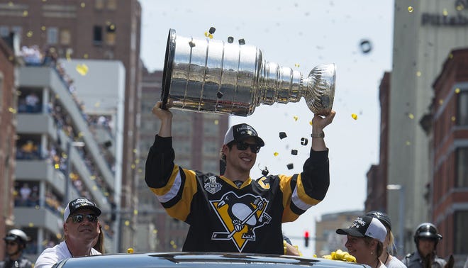 Sidney Crosby raises the Stanley Cup during the victory celebration in downtown Pittsburgh on June 15, 2016.