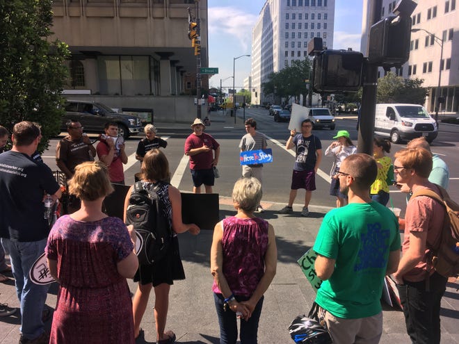 Local faith leaders, activists and others gather outside LeVeque Tower Monday morning to protest deportation of immigrants and refugees and support Bijou Sene, a Cincinnati resident originally from Senegal, as she meets with U.S. Immigration and Customs Enforcement. [DANAE KING/DISPATCH]