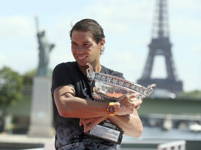 Rafael Nadal poses for photos with his French Open trophy aboard a barge cruising on the Seine river on Monday in Paris. Nadal defeated Switzerland's Stan Wawrinka in the men's final at the French Open tennis championships on Sunday. [David Vincent / AP]